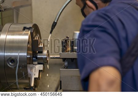 Closeup Scene The Lathe Machine Operator Working With  Turning Machine. The Metalworking Process By 