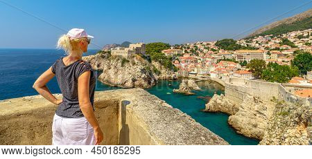 Girl With Hat On Dubrovnik City Walls Of Croatia. Fort Lovrijenac Fortress In West Harbour. Dubrovni