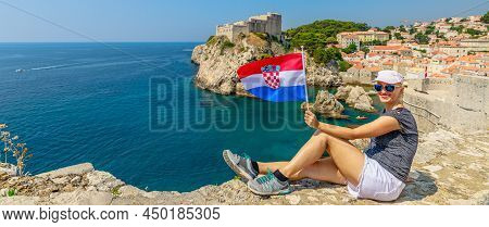 Girl With Croatian Flag On Dubrovnik City Walls Of Croatia. Fort Lovrijenac Fortress In West Harbour
