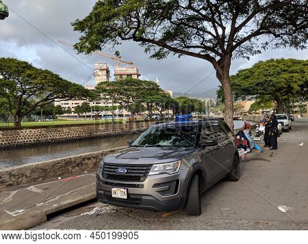 Honolulu - February 27, 2018:  Police Officers Talk To Homeless Man On Sidewalk With Their Ford Suv 