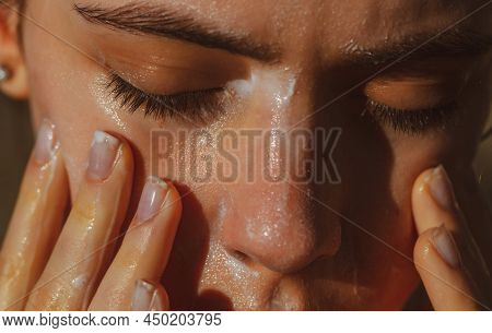 Acne Protection. Girl Washing Face With Cleancing Products. Cosmetics For Skincare.