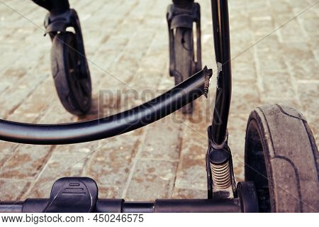 Broken Chassis Of A Baby Stroller, Damage To The Crossbar Of The Metal Frame Of The Pram