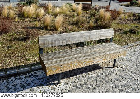 Perennial Bed Mulched With Gray Gravel In Front Of A Limestone Stone Wall In A Square With Benches W