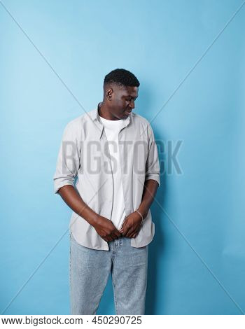 An African-american Man In White Clothes Stands On An Isolated Blue Background