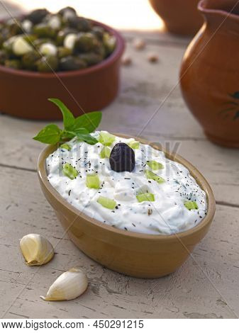 The Well Known Greek Dish,tzatziki,yogurt,cucumber Cubes,garlic,olive Oil,vinegar,served On A Wooden