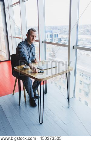 Happy Man With Coffee Calling Via Smartphone While Remote Working Laptop At Work Desk, Cheerful Free