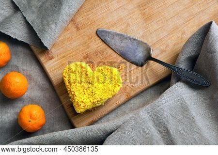 Yellow Cake Heart Shaped With Mango Filling And Tangerines. Delicate Dessert Combines Juicy Tropical