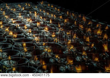 Detail Of Many Red Votive Candles Light Inside Chinese Temple. Rows Of Votive Candles In Glass With 