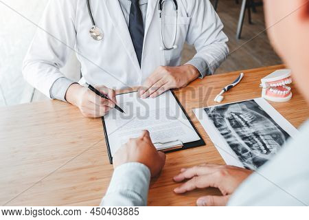 Dentist With Male Patient Presenting Discussing Dental Problems X-ray Image Film In Dental Office