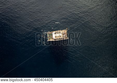 From Above Drone View Of Catamaran Floating On Rippling Sea Water Amidst Seabirds During Summer Trip