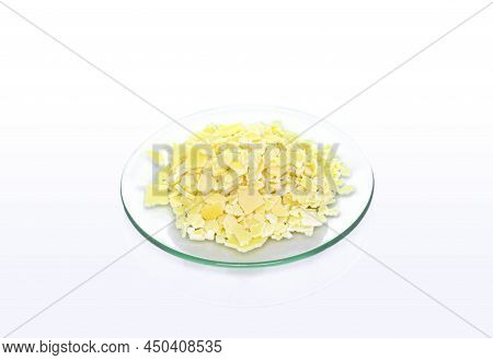 Closeup Chemical Ingredient On White Laboratory Table. Sodium Sulfide Flake In Chemical Watch Glass.