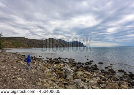 A Boy On The Shore Of The Fox Bay - A Bay Of The Black Sea Near The Kara-dag Mountain Range.