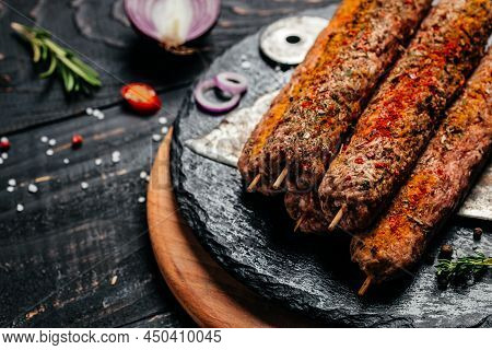 Raw Lula Kebab On Skewers With Spices On A Cutting Board Light Background. Lula Kebab, Traditional C