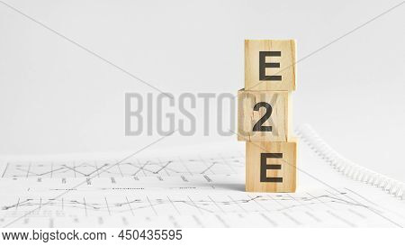 E2e - Letters On Wooden Cubes. Concept On Cubes And Diagrams On A Green Background. Business As Usua