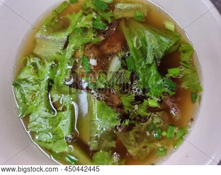 Clear Soup From Chicken Bone In A White Cup With Few Vetgetables. Focus At A Point