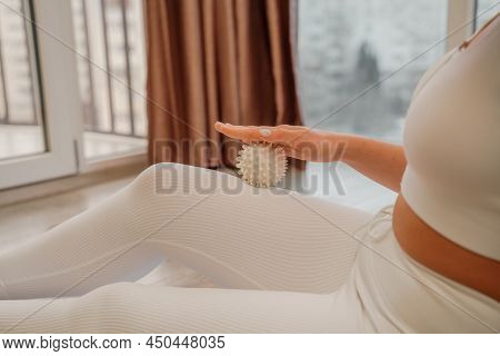 Athletic Slim Caucasian Woman Doing Thigh Self-massage With A Massage Ball Indoors. Self-isolating M