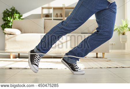 Close Up Of Legs Of Unknown Man Falling Due To What He Stumbles On Power Cord At Home.