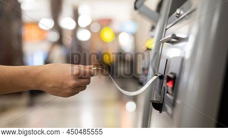 A Woman Takes A Train Ticket From A Self-service Ticket Office.