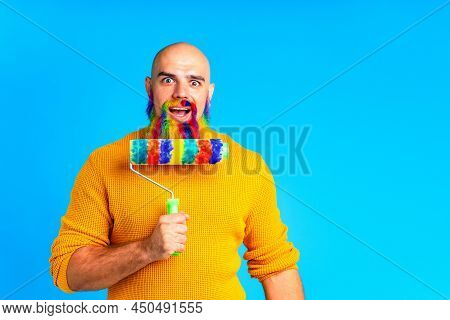 Handsome Man With Raindow In Beard And Yellow Sweater In Blue Studio Baclground