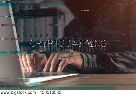 Cryptojacking Concept With Faceless Hooded Hacker Working On Laptop Computer, With Glitch Effect And