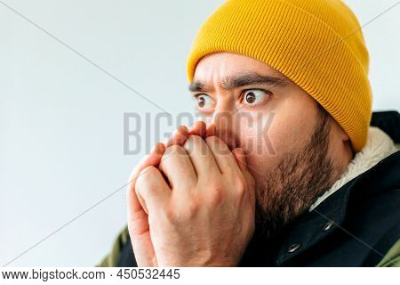 Close Up Of A Frozen Young Bearded Man In Winter Coat Posing Isolated On Grey Wall Background, Studi