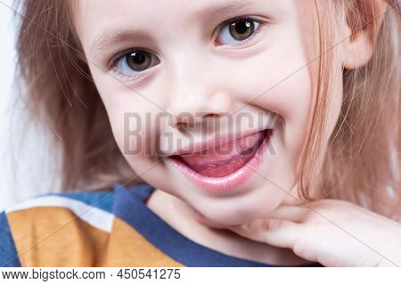Six-year Old Caucasian Girl Shows Myofunctional Trainer. Dental Tariner Is Made To Help Equalize The