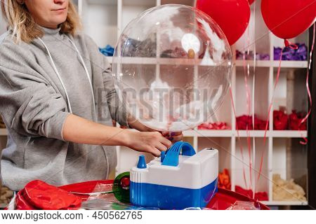 Woman Aerodesigner Stretches Air Clear Balloon With White Feathers Inside