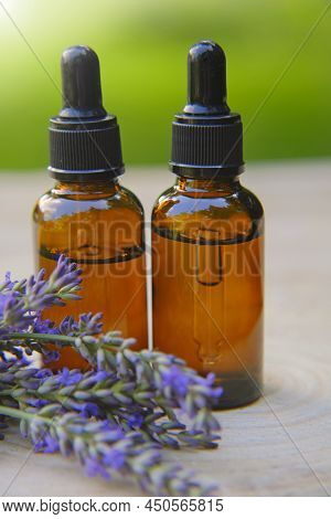 Lavender Oil And Lavender Sprigs On Blurred Green Background.base Oil For Massage And Care For Face 