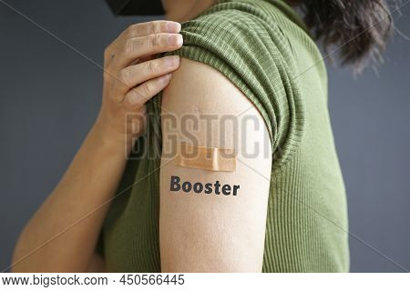 Close Up View Of Woman Arm With Bandage And The Word Booster - Getting Vaccinated Immunity. Inoculat