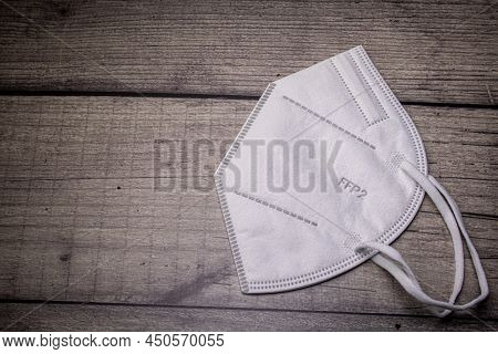 Ffp-2 Mask For Protection Against Aerosols E.g. Against Corona Viruses On Wooden Background And Copy