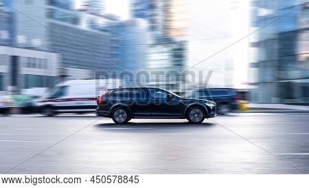 Volvo V90 Car Moving On The Street. Estate Vehicle Driving Along Wet Slippery Street In City With Bl