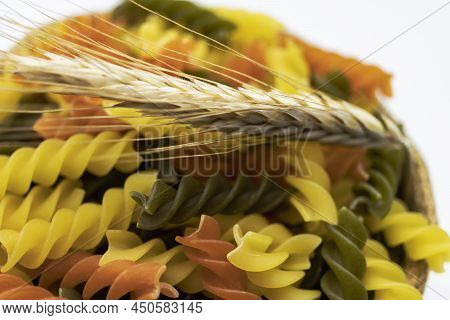 Three Colors Pasta Made From Durum Wheat. Pasta Fusilli Tricolor Background. Abstract Texture Of Col