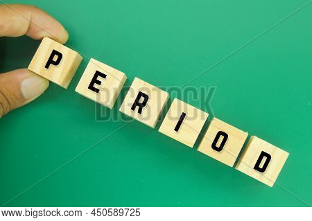 Hand Holding A Wooden Cube With The Word Period
