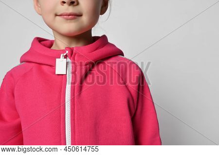 Close-up Of A Child In A Pink Jumpsuit Or Sweatshirt With A Zipper, Headless Photo. Shoulders, Neck