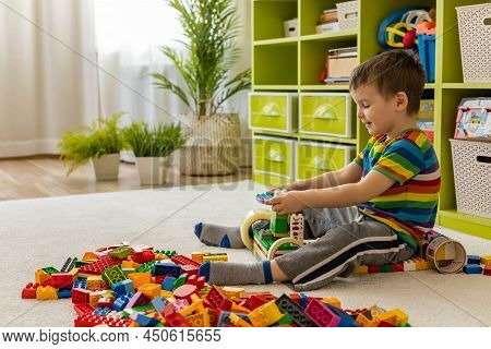 Khabarovsk, Russia, February 25, 2022. Smiling Male Kid Constructing Toy Car With Lego Duplo Details