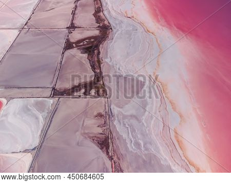 Flying Over A Pink Salt Lake. Salt Production Facilities Saline Evaporation Pond Fields In The Salty