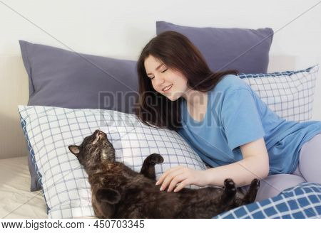 Happy Teen Girl With Black Cat In White Bedroom