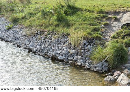 Strengthening The Banks Of The River, Mesh And Stones. Landscape River Bank And Large Stones With Me