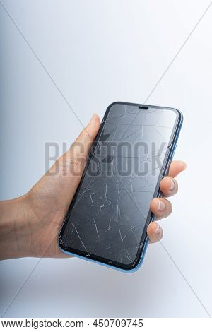 Smartphone With Badly Damaged Screen On A White Background