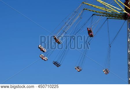 Entertainment Industry With Carousels At Low Altitude Spins Brave Visitors On A Ferris Wheel. Weaker