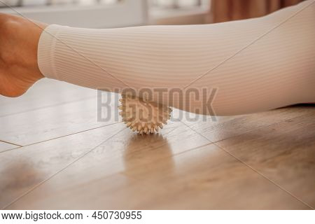Athletic Slim Caucasian Woman Doing Thigh Self-massage With A Massage Ball Indoors. Self-isolating M