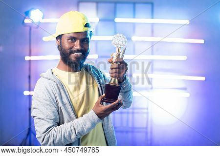 Happy Smilig Young Dancer With Winner Trophy In Hands Looking At Camera On Stage With Copy Space - C