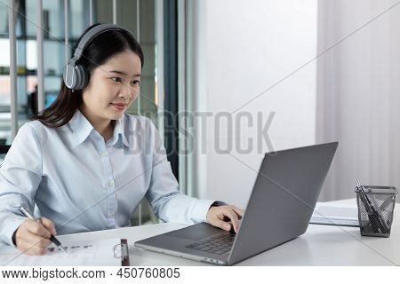 Young Asian woman are greeting friends and manager through video chats and greeting them with cheerf