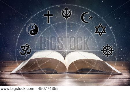 Open Book On Wooden Table With Religious Symbols And Universe Background. Concept Of The Study Of Re
