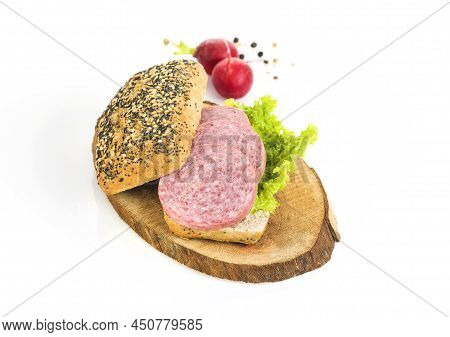 A Sandwich Of Turkey Meat Salami And Lettuce On A Wooden Board