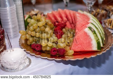 Fruit Slicing At A Wedding Banquet. Watermelon, Grapes, Strawberry, Orange, Plum, Pear, Dinha, Peach