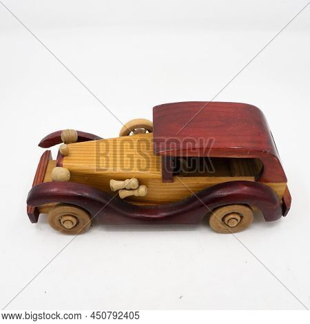 Side View Of An Vintage Model Brown Wooden Toy Car Isolated In A White Background