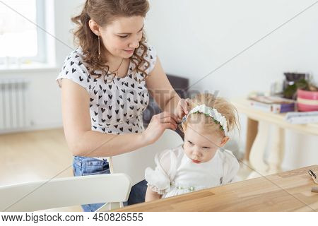 Mother Helps To Put On Cochlear Implant For Her Deaf Little Daughter. Hearing Aid And Deafness Conce