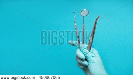 Set Of Medical Dental Equipment And Dental Floos In Glove Hand On Blue Background. Copy Space