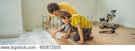 Banner, Long Format Father And Son Installing New Wooden Laminate Flooring On A Warm Film Floor. Inf